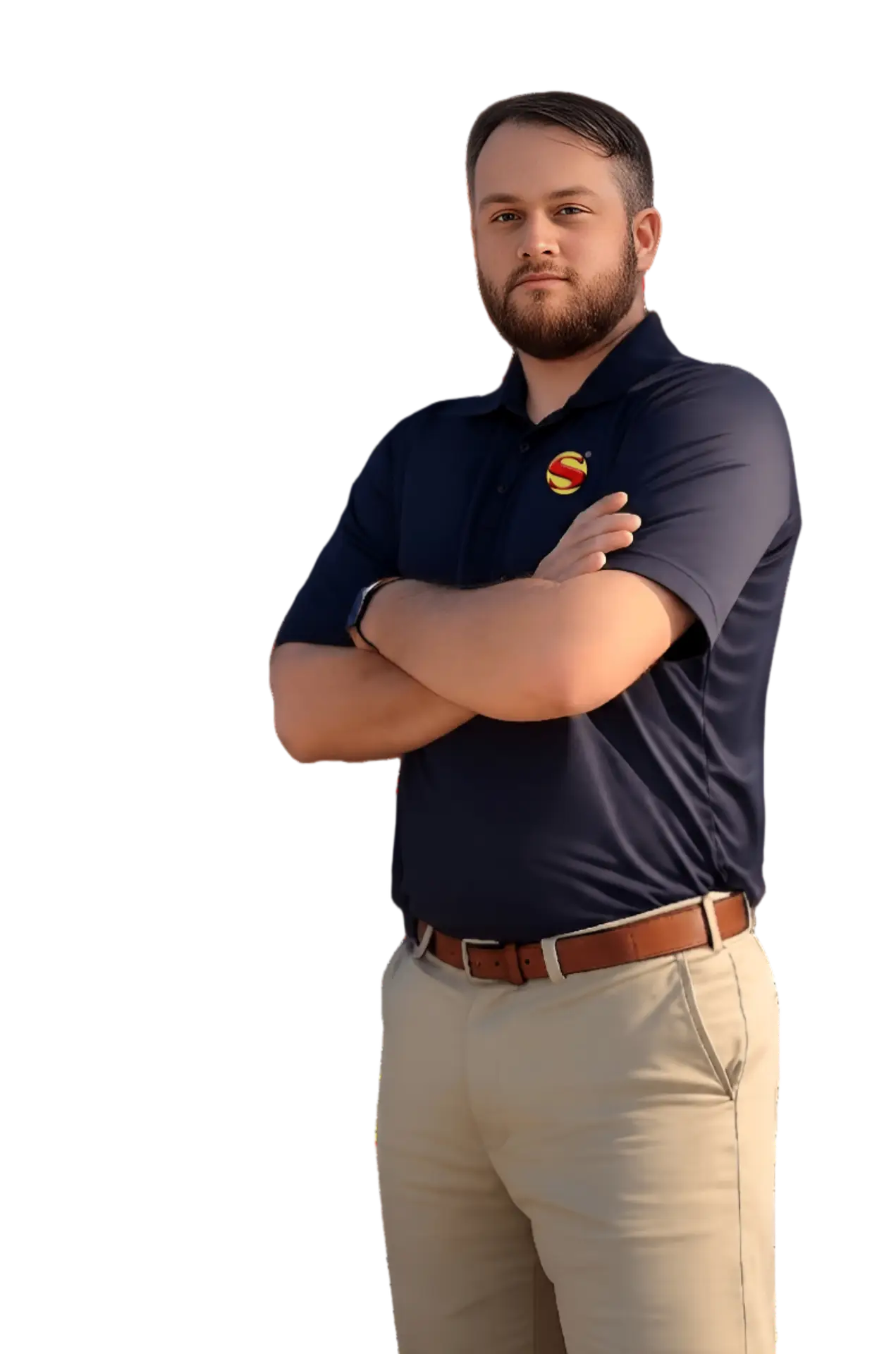 A man with a beard stands confidently with arms crossed, wearing a navy blue polo shirt with a colorful logo and khaki pants, against a plain light background.